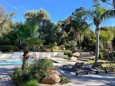 a swimming pool in a yard with chairs and trees at Villa Mare e Monte - Cala Rossa in Porto-Vecchio
