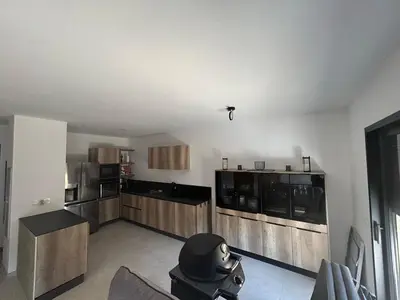 a large kitchen with wooden cabinets in a room at Casa Mana-Y in Zonza