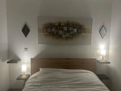 a bedroom with a bed with two lamps on it at Casa Mana-Y in Zonza