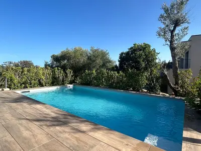 a swimming pool in a yard with a wooden deck at Casa Mana-Y in Zonza