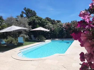 a swimming pool with two umbrellas in a yard at Villa LICCIA in Prunelli-di-Fiumorbo