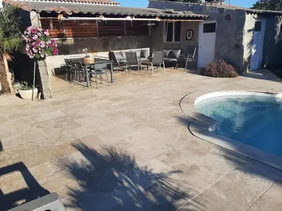 a patio with a swimming pool and a table and chairs at Villa LICCIA in Prunelli-di-Fiumorbo