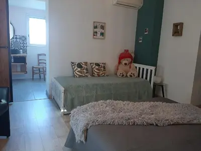 a bedroom with two beds with a teddy bear sitting on it at Villa LICCIA in Prunelli-di-Fiumorbo