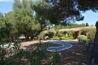 a garden with a pond in the middle of a yard at Mini villa dans résidence calme wifi piscine mer à pied in Serra-di-Ferro