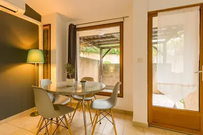 a dining room with a table and chairs at Mini villa dans résidence calme wifi piscine mer à pied in Serra-di-Ferro