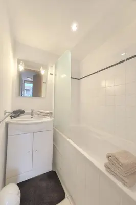 a white bathroom with a tub and a sink at Mini villa dans résidence calme wifi piscine mer à pied in Serra-di-Ferro