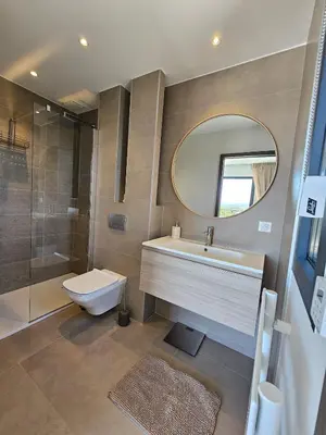 a bathroom with a sink and a toilet and a mirror at Roof Top AVRETTU - Vue Panoramique & Design in Porto-Vecchio