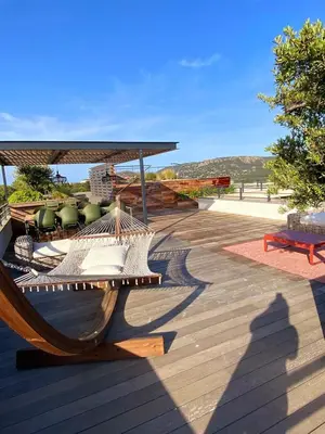 a hammock on a deck with a view of the ocean at Roof Top AVRETTU - Vue Panoramique & Design in Porto-Vecchio