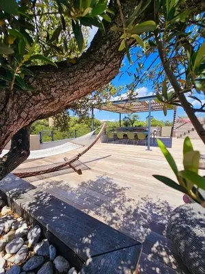 a hammock under a tree in a park at Roof Top AVRETTU - Vue Panoramique & Design in Porto-Vecchio
