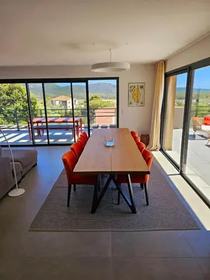 a dining room with a wooden table and red chairs at Roof Top AVRETTU - Vue Panoramique & Design in Porto-Vecchio