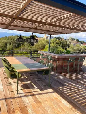 a wooden table and chairs on a deck at Roof Top AVRETTU - Vue Panoramique & Design in Porto-Vecchio