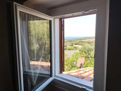 a window in a room with a view of a yard at La Maisonnette , 2 personnes, charming cottage, 4 km from the beaches in Cargèse