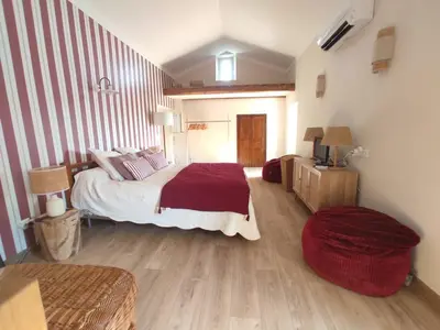 a bedroom with a large bed with a red blanket at La Maisonnette , 2 personnes, charming cottage, 4 km from the beaches in Cargèse