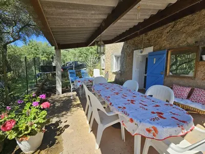 a table and chairs on a patio with flowers at La Maisonnette , 2 personnes, charming cottage, 4 km from the beaches in Cargèse