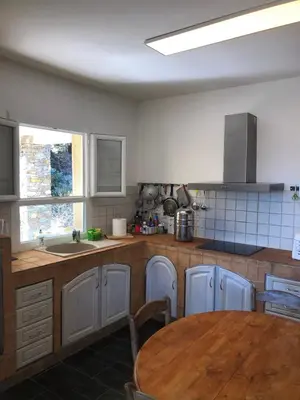 a kitchen with a table and a sink and a counter at Villa avec vue et piscine privée in Moltifao