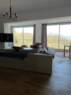 a living room with two couches and a large window at Villa avec vue et piscine privée in Moltifao