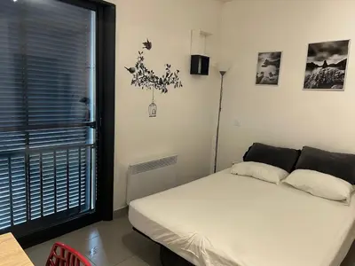 a bedroom with a white bed and a window at Charmant studio en centre-ville in Corte
