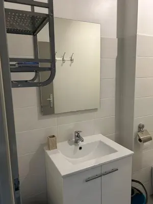 a bathroom with a white sink and a mirror at Charmant studio en centre-ville in Corte