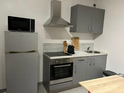 a kitchen with a sink and a stove and a refrigerator at Charmant studio en centre-ville in Corte
