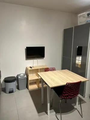 a room with a table and a desk with a television at Charmant studio en centre-ville in Corte