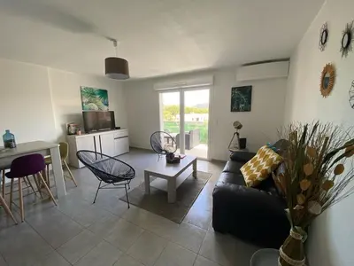 a living room with a couch and a table at Entire air-conditioned accommodation, Porto Vecchio center in Porto-Vecchio