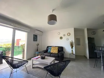 a living room with a couch and chairs and a table at Entire air-conditioned accommodation, Porto Vecchio center in Porto-Vecchio