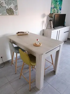 a white table with two chairs and a television at Entire air-conditioned accommodation, Porto Vecchio center in Porto-Vecchio