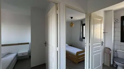 a room with a bedroom with a bed and a door at Location appartement 6 pers les marines de Bravone in Linguizzetta
