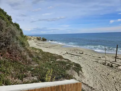 a sandy beach with the ocean in the background at Location appartement 6 pers les marines de Bravone in Linguizzetta