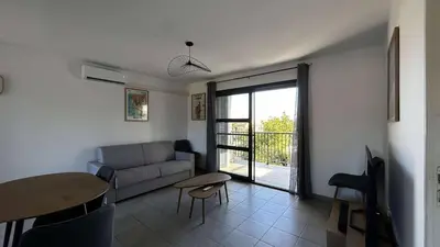 a living room with a couch and a table at Location appartement 6 pers les marines de Bravone in Linguizzetta