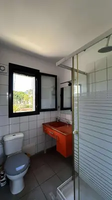 a bathroom with a toilet and a sink and a window at Location appartement 6 pers les marines de Bravone in Linguizzetta