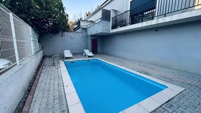 a swimming pool with two chairs next to a building at Location appartement 6 pers les marines de Bravone in Linguizzetta