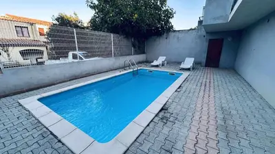 a swimming pool in a courtyard next to a building at Location appartement 6 pers les marines de Bravone in Linguizzetta