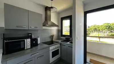 a kitchen with stainless steel appliances and a window at Location appartement 6 pers les marines de Bravone in Linguizzetta