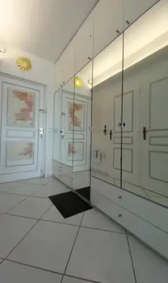 a bathroom with a mirror and two white doors at Appartement les pieds dans l'eau in Calcatoggio