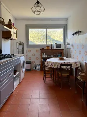 a kitchen with a table and a dining room at Vista di Nata appartement en ville entre mer et maquis in Ajaccio