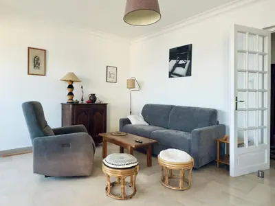 a bedroom with a bed with a blue and yellow blanket at Vista di Nata appartement en ville entre mer et maquis in Ajaccio