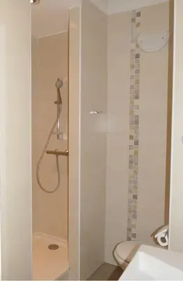 a white bathroom with a shower and a sink at Agréable triplex Nelly situé en moyenne montagne in Cristinacce