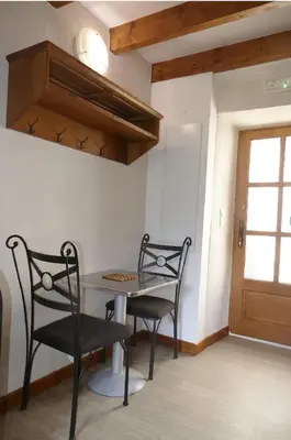 a dining room with two chairs and a table at Agréable triplex Nelly situé en moyenne montagne in Cristinacce