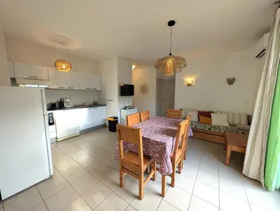 a kitchen and living room with a table and chairs at T3 - accès direct plage dans résidence avec piscine in Poggio-Mezzana