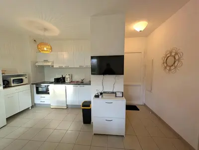 a kitchen with white cabinets and a counter top at T3 - accès direct plage dans résidence avec piscine in Poggio-Mezzana