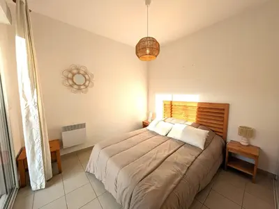 a bedroom with a large bed in a room at T3 - accès direct plage dans résidence avec piscine in Poggio-Mezzana
