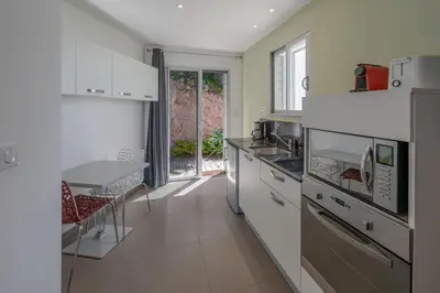 a kitchen with white appliances and a table in it at Villa SOPRA - Sea View & Pool - Porto-Vecchio in Porto-Vecchio