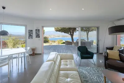 a living room with a white couch and a table and chairs at Villa SOPRA - Sea View & Pool - Porto-Vecchio in Porto-Vecchio