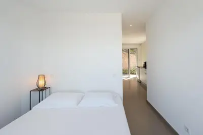 a white bedroom with a bed and a hallway at Villa SOPRA - Sea View & Pool - Porto-Vecchio in Porto-Vecchio