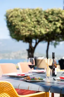 a table with two glasses of wine and food on it at Villa SOPRA - Sea View & Pool - Porto-Vecchio in Porto-Vecchio