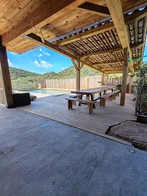 a group of picnic tables under a wooden pavilion at Villa KECA in Bonifacio