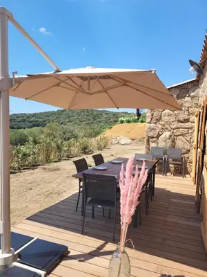 a living room with a table and chairs and a couch at Bergerie en pierre piscine chauffée Sotta in Sotta