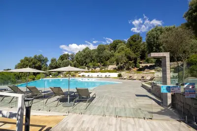 a large swimming pool with chairs and umbrellas at Domaine d'Arca - Hugo 01 - 5 personnes in Porto-Vecchio