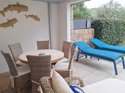 a patio with a table and chairs and a television at Domaine d'Arca - Hugo 01 - 5 personnes in Porto-Vecchio